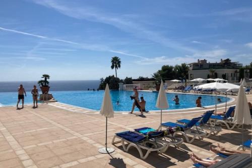 un groupe de personnes assises autour d'une piscine dans l'établissement Apartment with sea view pool and beach, à Cannes