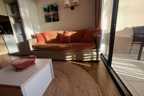 - un salon avec un canapé et des oreillers dans l'établissement Apartment with sea view pool and beach, à Cannes