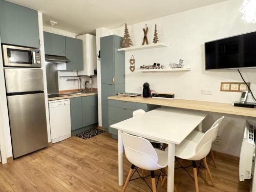 - une cuisine avec une table blanche et des chaises blanches dans l'établissement Place de la Mairie. Joli T2 4P - Terrasse et vue., à Cauterets