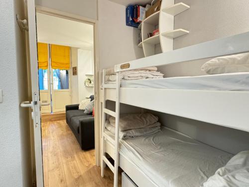 une chambre avec deux lits superposés et un canapé dans l'établissement Place de la Mairie. Joli T2 4P - Terrasse et vue., à Cauterets