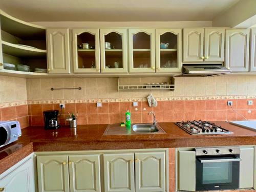a kitchen with white cabinets and a sink at Appartement Central Rabat Tour Hassan in Rabat