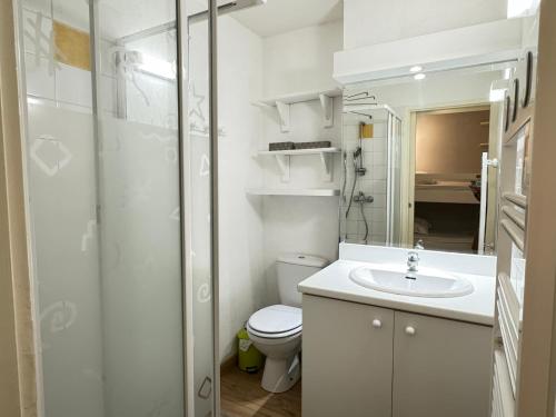 une salle de bain blanche avec des toilettes et un lavabo dans l'établissement Place de la Mairie. Joli T2 4P - Terrasse et vue., à Cauterets