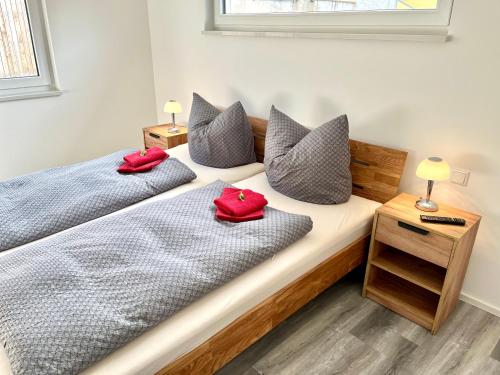 2 camas en una habitación con almohadas rojas. en Haus Winter, en Naumburg