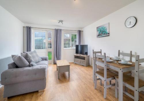 a living room with a couch and a dining room table at Stylish Crawley 1BR with Private Garden Free Parking Near Gatwick LGW in Three Bridges