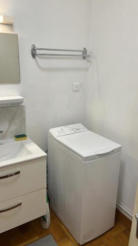 - un petit réfrigérateur blanc dans une chambre blanche dans l'établissement La Sirène, à 250 m de la plage, T2 lumineux avec une terrasse spacieuse de15m², à Saint-Cyprien