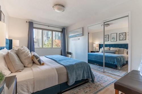 a bedroom with a large bed and a mirror at Vibrant Downtown, King Bed, Work Desk & Kitchen in Seattle