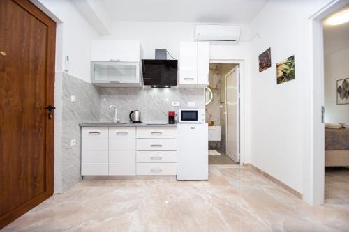 a kitchen with white cabinets and a counter top at Stone Villa with pool Montenegro Star in Kaluđerac