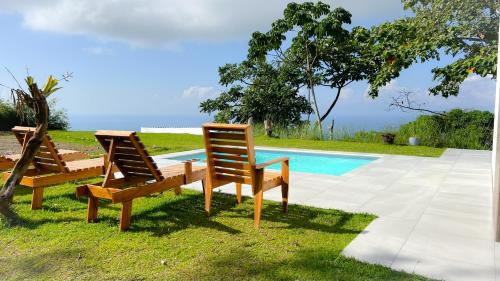 two chairs and a table next to a swimming pool at Canavida Villas & Resort in Uvita