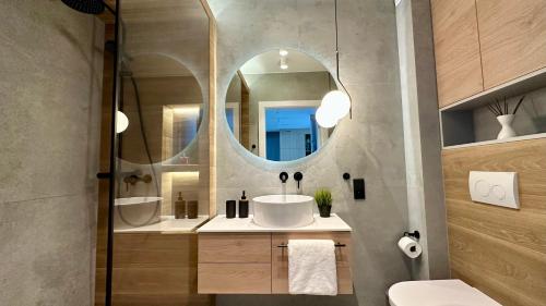 Un baño con dos lavabos y un espejo grande. en Apartament Scandi, basen & spa, en Rewal