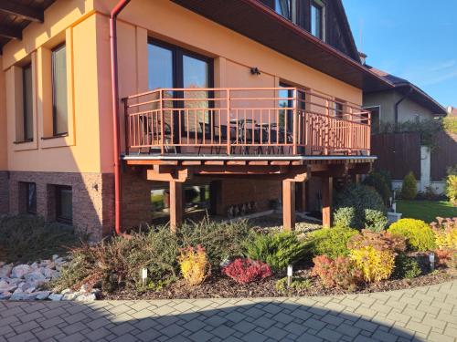 a house with a deck on the side of it at Šarmír Apartmány in Bobrovec