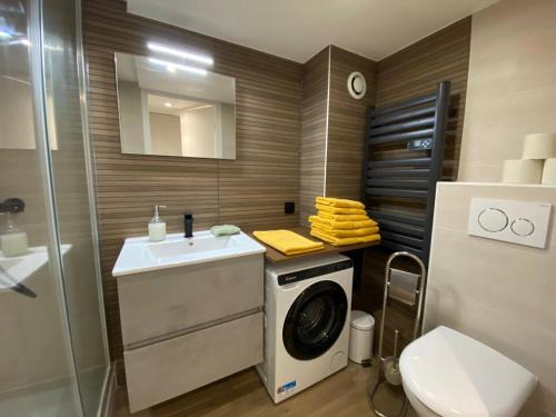 une salle de bain avec une machine à laver et un lavabo dans l'établissement Hyper centre : Appartement Déco Atelier ou Studio Mezzanine, à Lyon