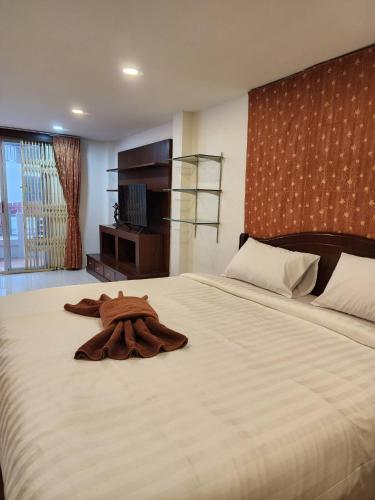 a robe laying on a bed in a bedroom at เอสเอสเฮ้าแอ๊ดอ่าวนาง in Ao Nang 