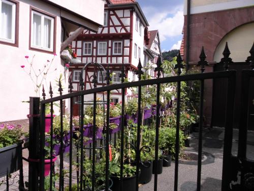 una recinzione di fronte a una casa con fiori di Ferienwohnungen Calwer Höfle Biergasse - für Firmen, Handwerker und Monteure a Calw