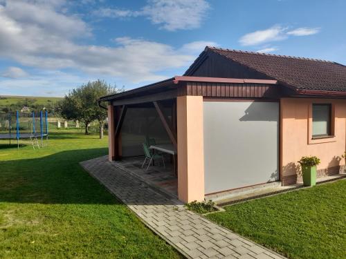 a building with a large white garage at Šarmír Apartmány in Bobrovec