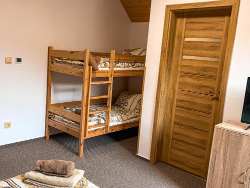 a bunk bed room with two bunk beds next to a door at Chata Perkaska in Žacléř