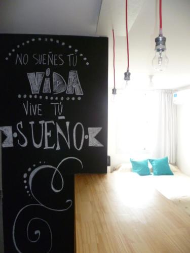 a room with a bed and a sign on the wall at Departamento Corrientes in Villa María