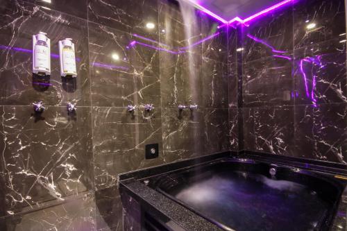 a bathroom with a black tub and purple lights at Adrenalina Motel Itaquera - Arena Corinthians in Sao Paulo