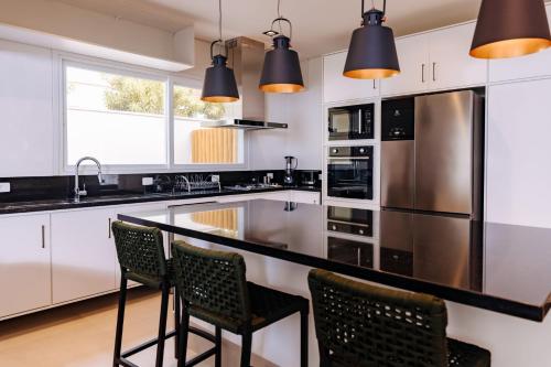 a kitchen with white cabinets and black counter tops at Vistabela Resort & Spa in São Sebastião