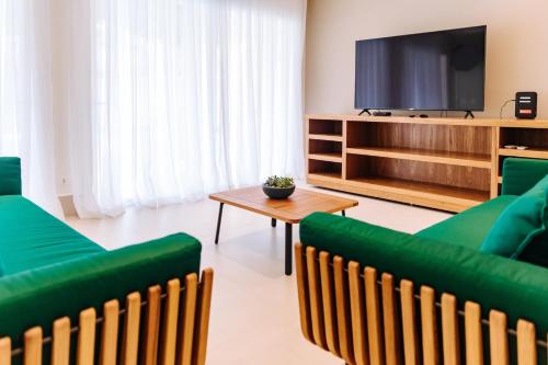 a living room with green furniture and a flat screen tv at Vistabela Resort & Spa in São Sebastião