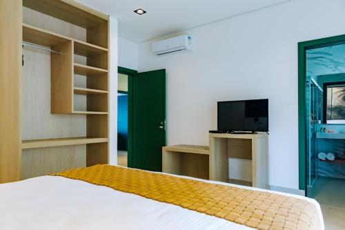 a bedroom with a bed and a tv in a room at Vistabela Resort & Spa in São Sebastião