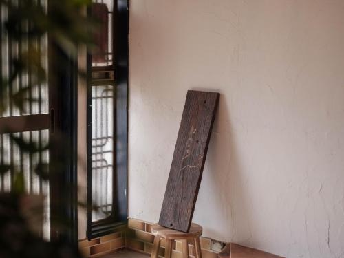 a wooden sign on the side of a wall at ゲストハウスはれのち in Furunoushigawa