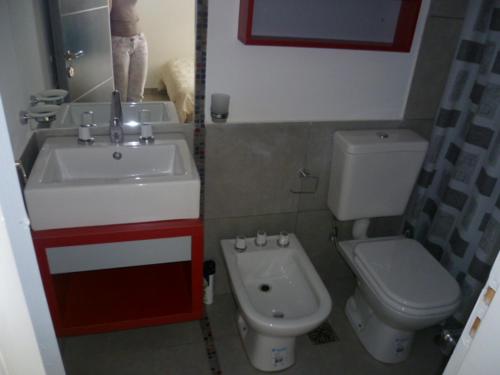 a bathroom with a sink and a toilet at Departamento Corrientes in Villa María