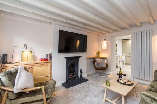a living room with a couch and a fireplace at Duncan's Cottage at Royal Hillsborough in Hillsborough