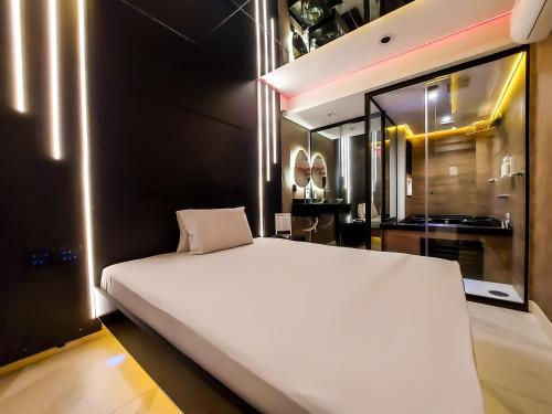 a bedroom with a large white bed and a mirror at Adrenalina Motel Itaquera - Arena Corinthians in Sao Paulo