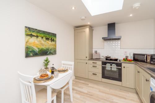a kitchen with a table and a dining room at Duncan's Cottage at Royal Hillsborough in Hillsborough