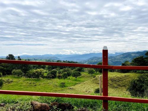 a red fence with a view of a mountain at Cabaña La Finca in Cervantes
