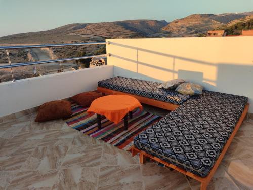 a balcony with a bench and a table and a view at Sea Breeze 4 in Imsouane