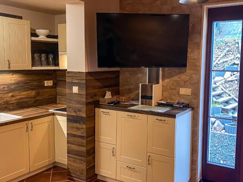 a kitchen with a flat screen tv on a wall at Chata Perkaska in Žacléř