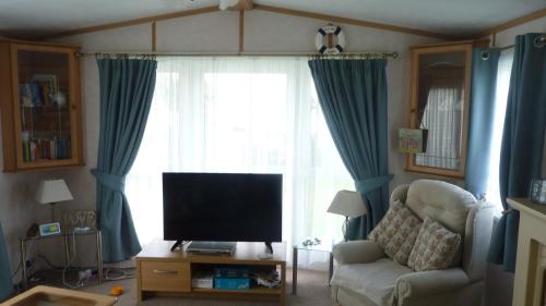 a living room with a tv and a couch and a window at Disabled access C10 Millfields caravan park 2 bedrooms lead person must be over 30 in Ingoldmells