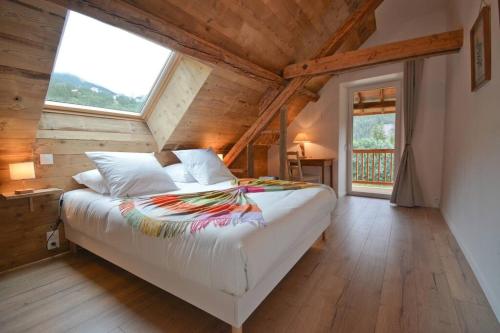 une chambre avec un grand lit dans un grenier dans l'établissement La Mélézière-Cimes-Appartement Grand Confort 120m2 6 personnes, aux Orres
