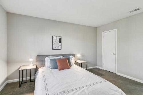 Un dormitorio blanco con una cama con dos mesas. en Barcelo At East Cobb O20 1 Bed 1 Bath Furnished, en Marietta