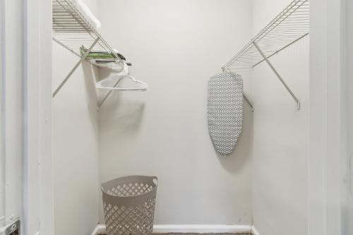 Un baño con una pared blanca y un bote de basura. en Barcelo At East Cobb Q1 1 Bed 1 Bath Furnished, en Marietta
