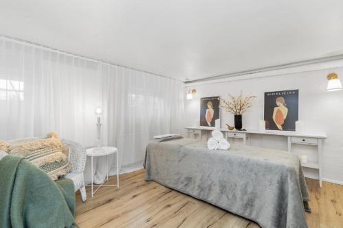 a white room with a bed and a chair at Luxury Villa in Downtown Reykjavik in Reykjavík