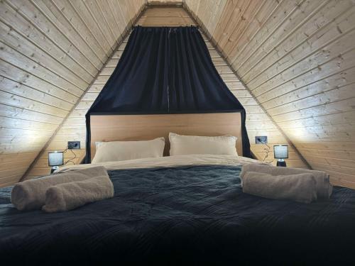 a bedroom with a large bed with two pillows on it at Apex Cottages in Kazbegi