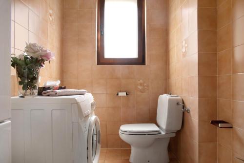 a bathroom with a toilet and a sink and a window at Il Bacio del sole 2 in Maccagno Inferiore