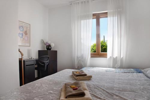 a bedroom with a bed and a desk and a window at Il Bacio del sole 2 in Maccagno Inferiore