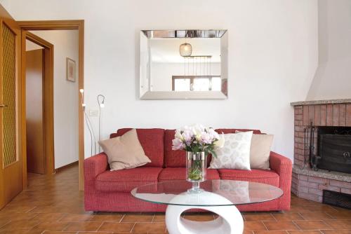 a living room with a red couch and a glass table at Il Bacio del sole 2 in Maccagno Inferiore