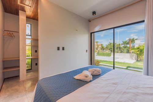 a bedroom with a bed and a large window at Summerville #117 - Luxo no Cumbuco by Carpediem in Cumbuco