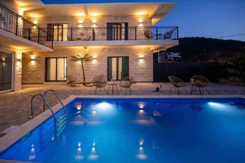 a villa with a swimming pool in front of a house at Stone Villa with pool Montenegro Star in Kaluđerac