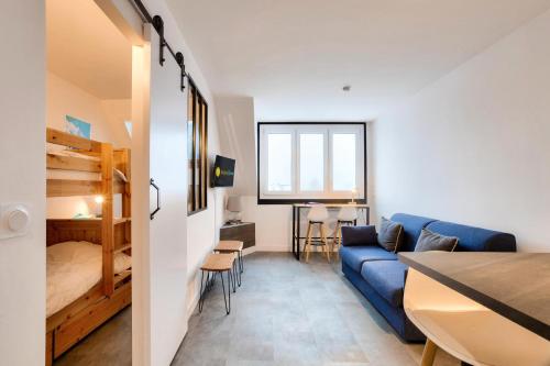 un salon avec un canapé bleu et une chambre dans l'établissement L'Aiguille - maeva Home - 2 Pièces 4 Personnes Prestige MAE-0414, à Chamonix-Mont-Blanc