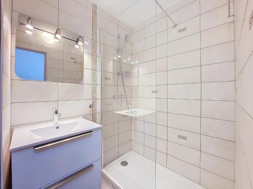 une salle de bain blanche avec un lavabo et un miroir dans l'établissement Studio proche des pistes et commerces, balcon exposé Sud, capacité 4 personnes - FR-1-275-177, à La Rosière