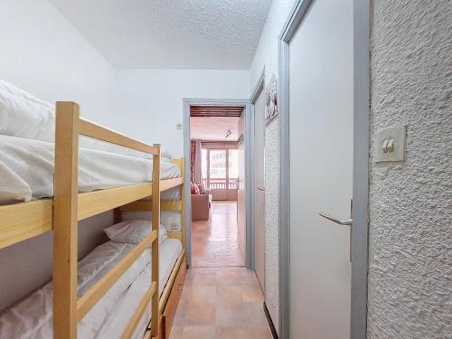 Cette chambre comprend 2 lits superposés et un couloir. dans l'établissement Studio proche des pistes et commerces, balcon exposé Sud, capacité 4 personnes - FR-1-275-177, à La Rosière