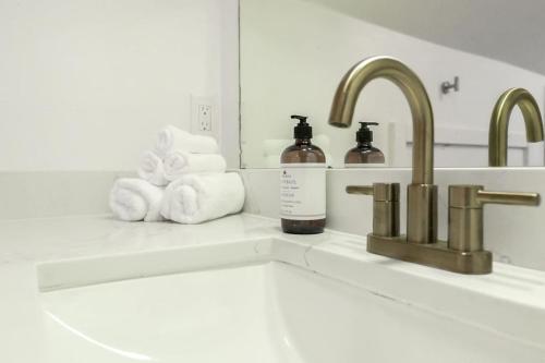 a bathroom counter with towels and a sink and a mirror at The Loft at Park Place Cozy Studio on the Park in Columbus