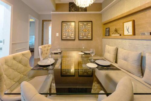 a dining room with a glass table and chairs at Belíssimo Apartamento MJ44 in Maringá