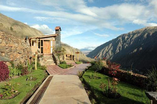 a house on a hill with mountains in the background at Stardome Spiritual Experience in Ollantaytambo