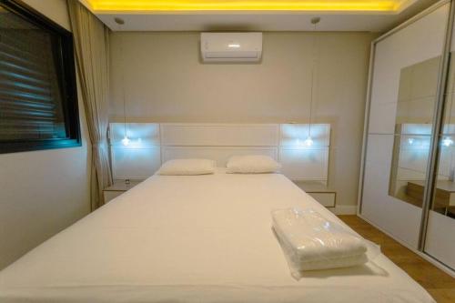 a bedroom with a large white bed in a room at Belíssimo Apartamento MJ44 in Maringá